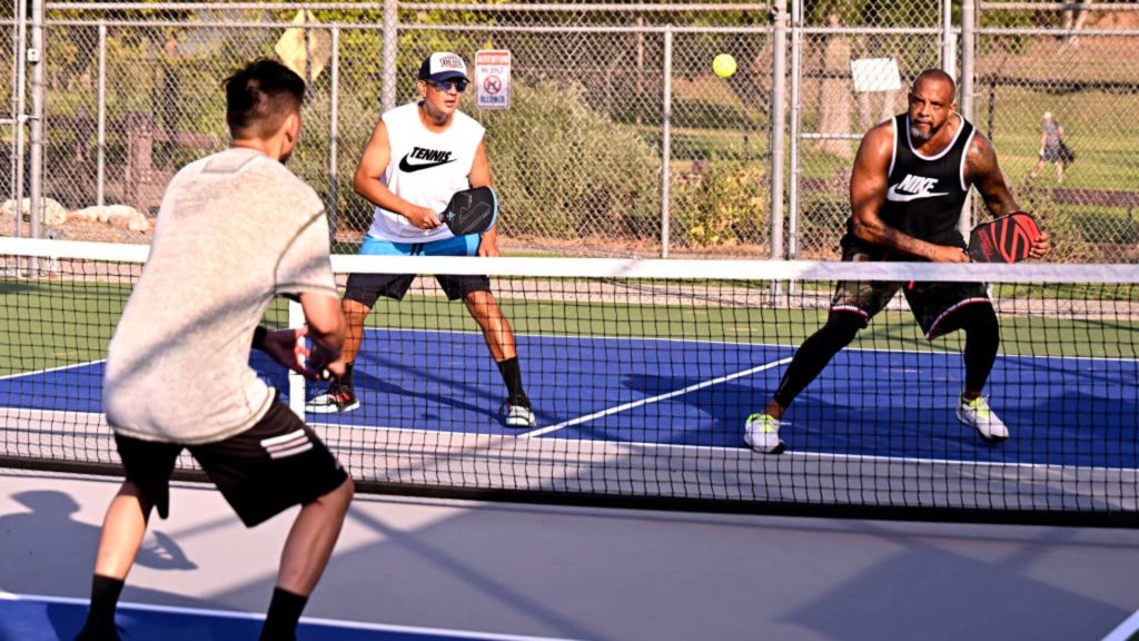 3 men plaiying pickleball