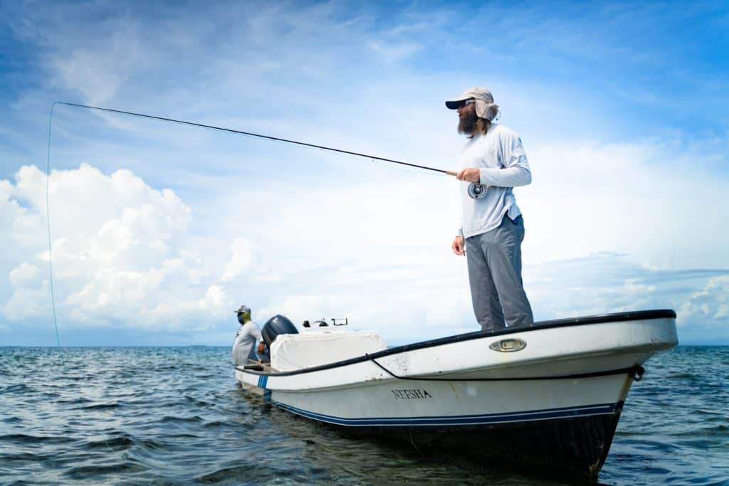 a man fishing from his white boat