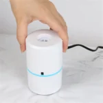 Mini electric vacuum pump GR-202 held on the valve of a vacuum storage bag