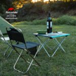 Naturehike FT08 folding table set up beside a camp chair at dusk
