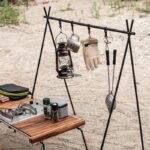 Naturehike NH19PJ082 folding camping rack - lantern and gear hanging from the bar