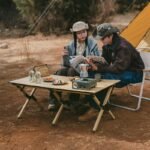 Two people eating at a Naturehike Star Jane L01 egg roll table outside a tent