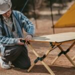 Rolling up the Naturehike Star Jane L01 egg roll table at a campsite