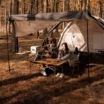 Naturehike CNH22JU038 folding table set up under a tarp in a forest